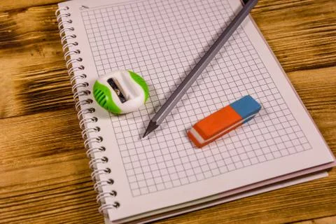 Open notepad and different stationeries on a wooden table Stock Photos