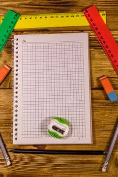 Open notepad and different stationeries on a wooden table. Top view Stock Photos