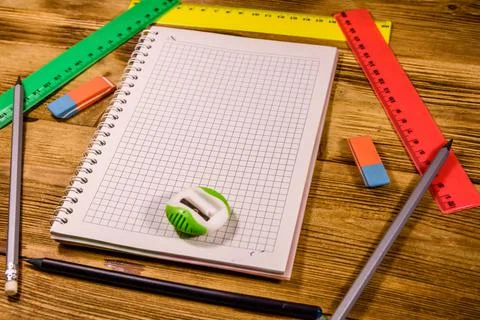 Open notepad and different stationeries on a wooden table Stock Photos