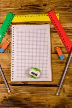 Open notepad and different stationeries on a wooden table. Top view Stock Photos