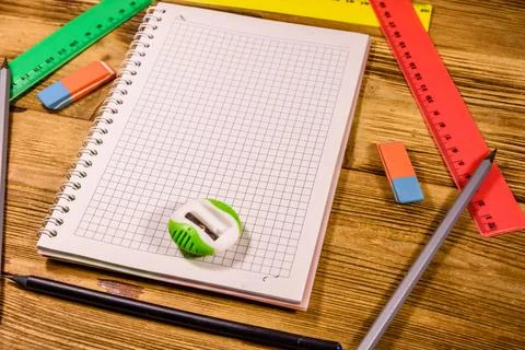 Open notepad and different stationeries on a wooden table Stock Photos