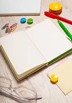 Open notepad with blank pages on table with office tools Stock Photos