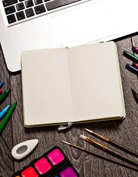 Open notepad with blank pages on table with office tools Foto stock