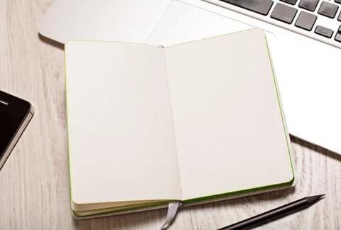 Open notepad with blank pages on table with laptop Stock Photos