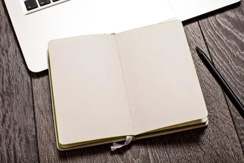 Open notepad with blank pages on table with laptop Stock Photos