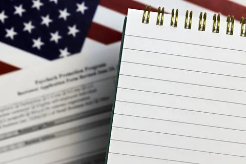 Open notepad with blank space, on a background of ppp form and the US flag Stock Photos