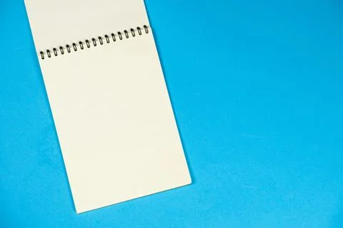 Open notepad on a blue background top view, space for text. Stock Photos