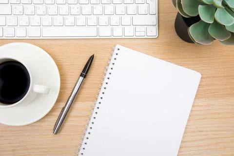 Open notepad, cup of coffee, pen ,moose, keyboard on wooden background spiral Stock Photos