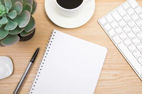 Open notepad, cup of coffee, pen ,moose, keyboard on wooden background spiral Stock Photos