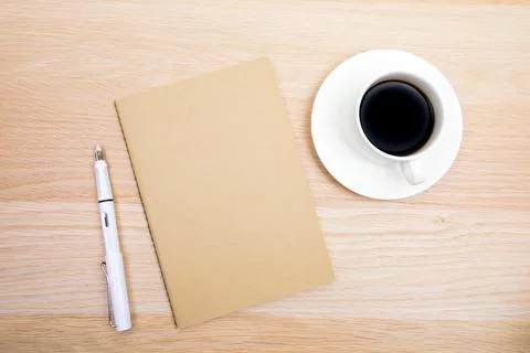 Open notepad, cup of coffee, pen  on wooden background spiral notebook on tab Stock Photos