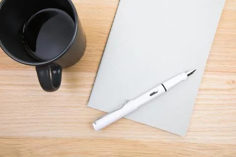Open notepad, cup of coffee, pen  on wooden background spiral notebook on tab Stock Photos