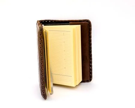 Open Notepad in dark brown genuine leather covers on a white background. Stock Photos