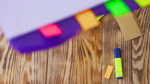 Open notepad is falling down on table / wooden background in slow motion. Stock Footage 77728065