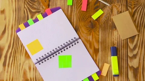 Open notepad is falling down on table / wooden background in slow motion. Video stock 77728071