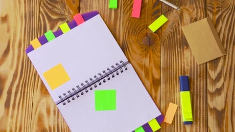 Open notepad is falling down on table / wooden background in slow motion. Stock Footage 77728183