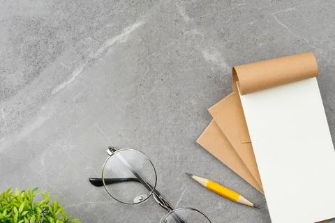 Open notepad on gray marble background. Stock Photos