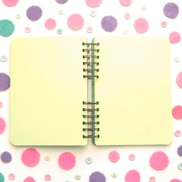Open Notepad green pages on colored confetti background. Stock Photos