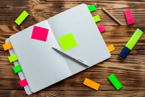 Open notepad with office supplies. Open notepad lies on a wooden desktop Stock Photos