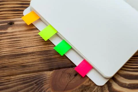 Open notepad with office supplies. Open notepad lies on a wooden desktop Stock Photos