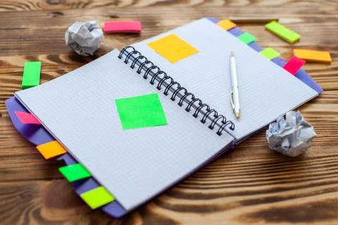 Open notepad with office supplies. Open notepad lies on a wooden desktop Stock Photos