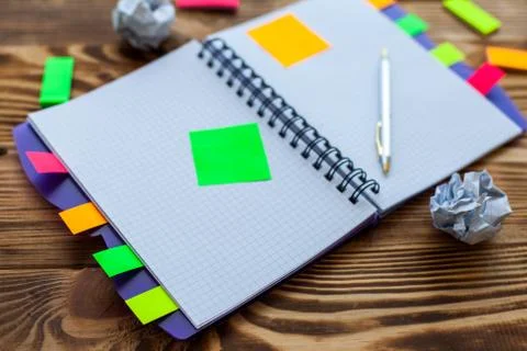 Open notepad with office supplies. Open notepad lies on a wooden desktop Stock Photos