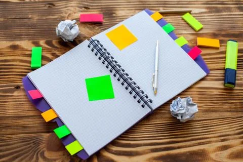 Open notepad with office supplies. Open notepad lies on a wooden desktop Stock Photos