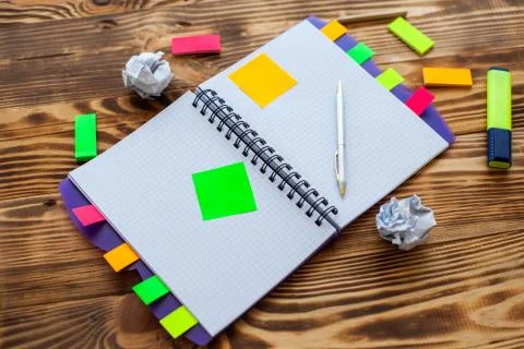Open notepad with office supplies. Open notepad lies on a wooden desktop Stock Photos