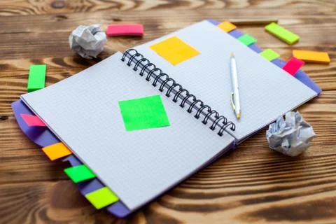 Open notepad with office supplies. Open notepad lies on a wooden desktop Stock Photos