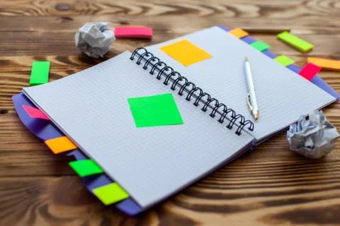 Open notepad with office supplies. Open notepad lies on a wooden desktop Stock Photos