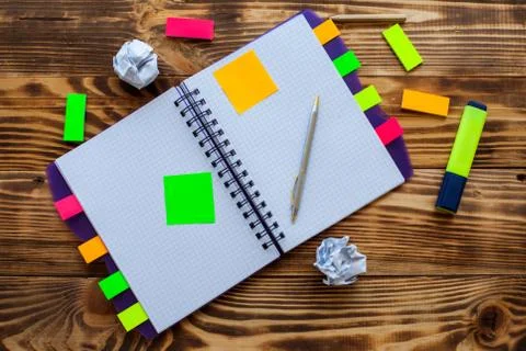Open notepad with office supplies. Open notepad lies on a wooden desktop Stock Photos