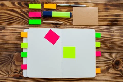 Open notepad with office supplies. Open notepad lies on a wooden desktop Stock Photos