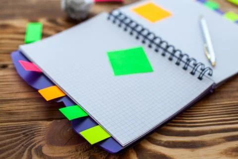 Open notepad with office supplies. Open notepad lies on a wooden desktop Stock Photos