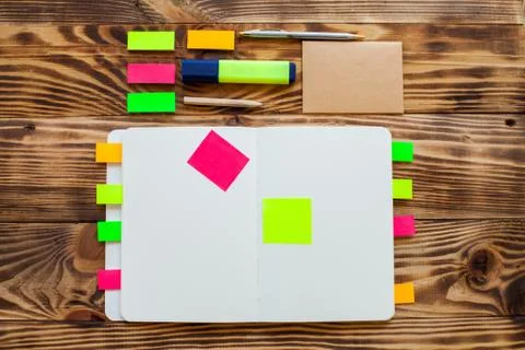 Open notepad with office supplies. Open notepad lies on a wooden desktop Stock Photos