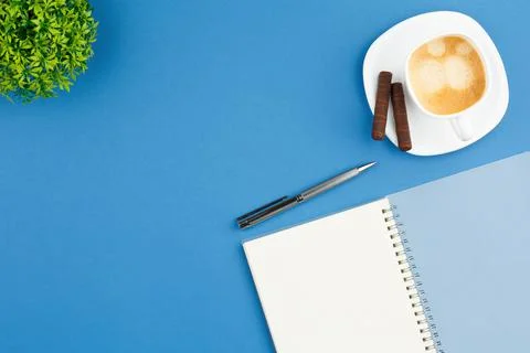 Open notepad with pen, cup of coffee and plant. Foto stock