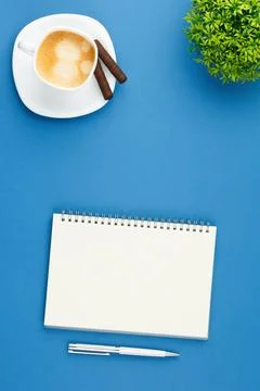 Open notepad with pen, cup of coffee and plant. Stock Photos