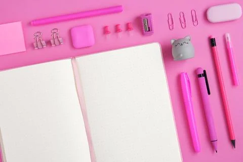 Open notepad with pink on magenta background. Eraser in form of cat. Flatly. Stock Photos