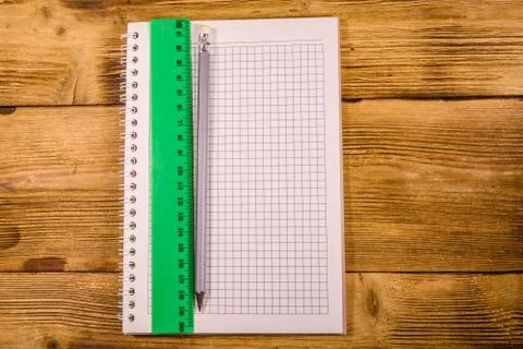 Open notepad, ruler and pencil on a wooden table. Top view Stock Photos