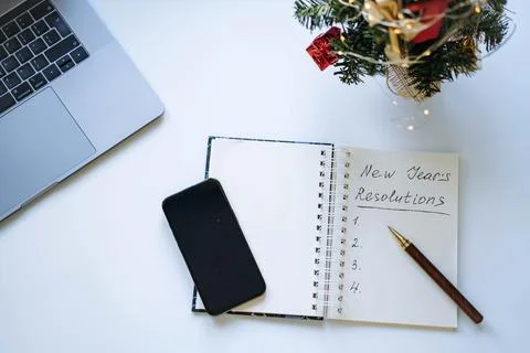 Open notepad with text new year resolutions. and empty list. laptop and smart Fotos de archivo