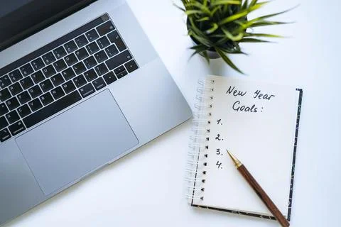 Open notepad with text new year resolutions. and empty list. laptop and smart Stock-Fotos