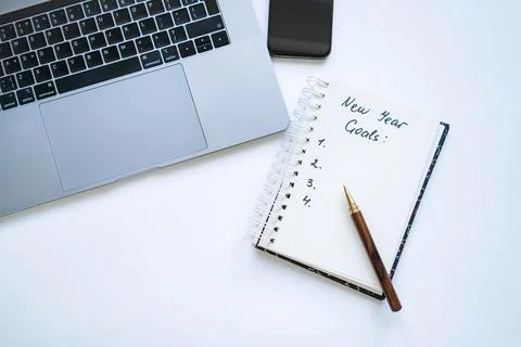 Open notepad with text new year resolutions. and empty list. Laptop and smart Fotos de archivo