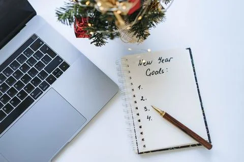 Open notepad with text new year resolutions. and empty list. Laptop and smart Fotos de archivo