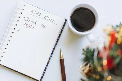 Open notepad with text new year resolutions. and empty list. laptop and smart 写真素材