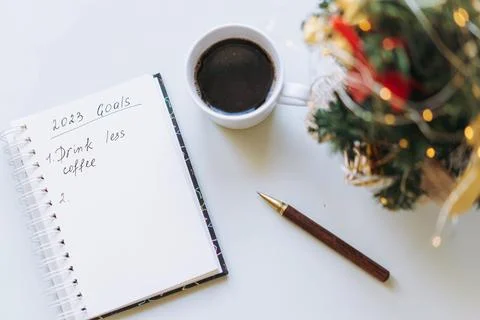 Open notepad with text new year resolutions. and empty list. laptop and Stock-Fotos