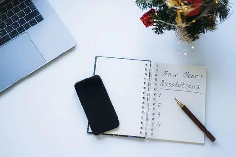 Open notepad with text new year resolutions. and empty list. laptop and Stock-Fotos