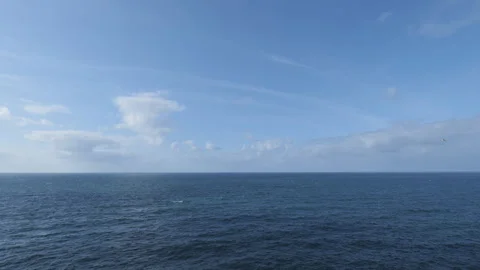 Open ocean under a clear blue sky with clouds. Stock Footage 296779475