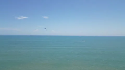 Open ocean view with a parasail in the distance and a speedboat 動画素材 284302586