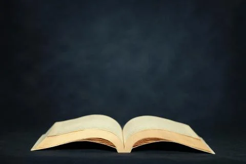 Open old book on dark background Stock Photos