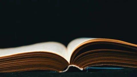 Open old book on dark background Stock Photos