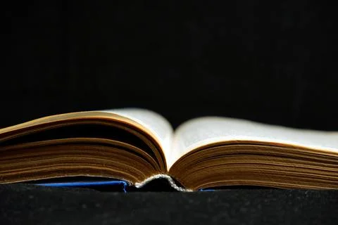 Open old book on dark background Stock Photos