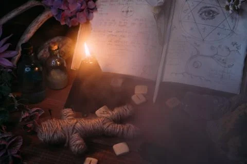 Open old book with magic spells, runes, black candle Stock Photos